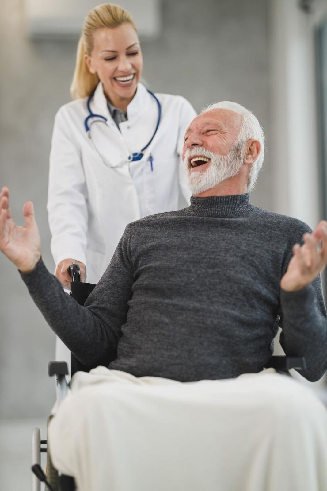 Nurse and elderly woman laughing together at a table