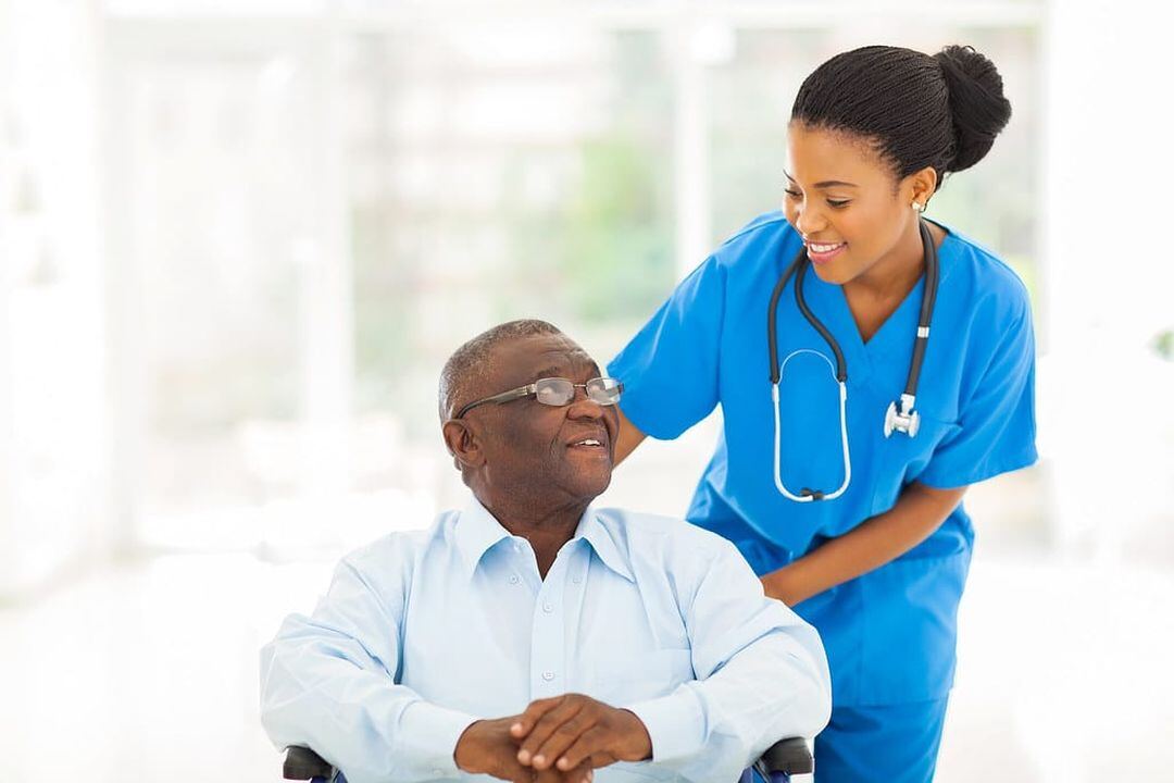 Caregiver with an elderly man in his wheelchair